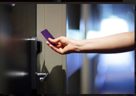 Person using card reader for door access control systems to access hotel room