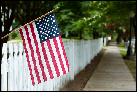 American flag on a white picket fence