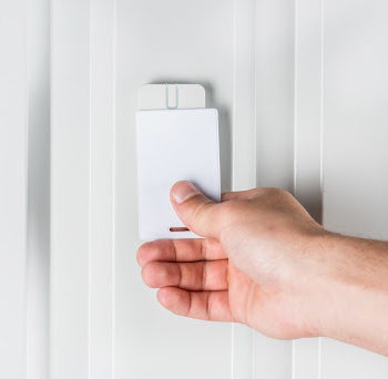 Person using a card based access control system mounted on a wall